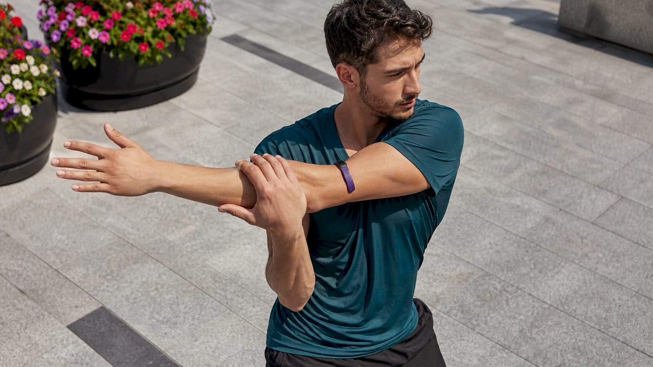 Male athlete stretching outdoors in athletic V-neck shirt