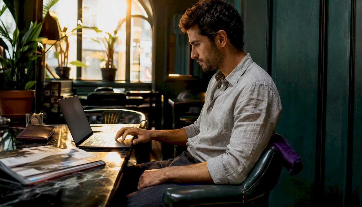 Man browsing premium menswear websites at desk
