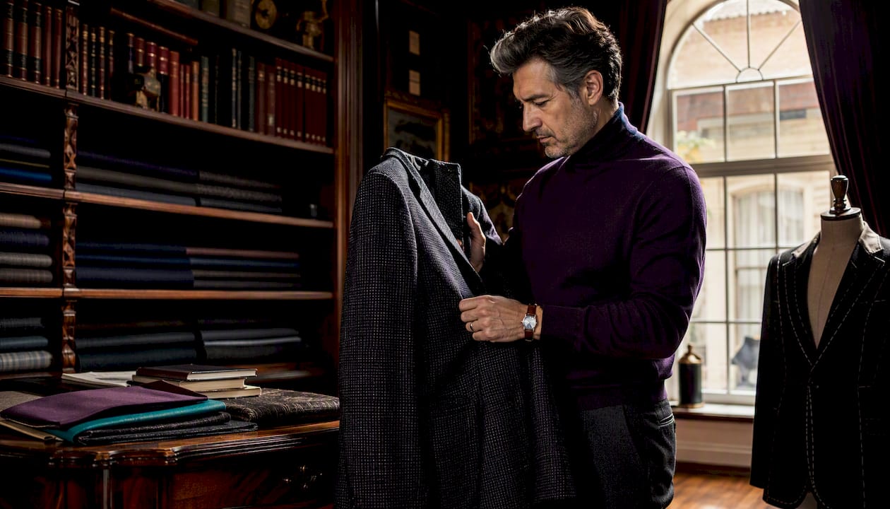 Man examining vintage wool blazer in showroom