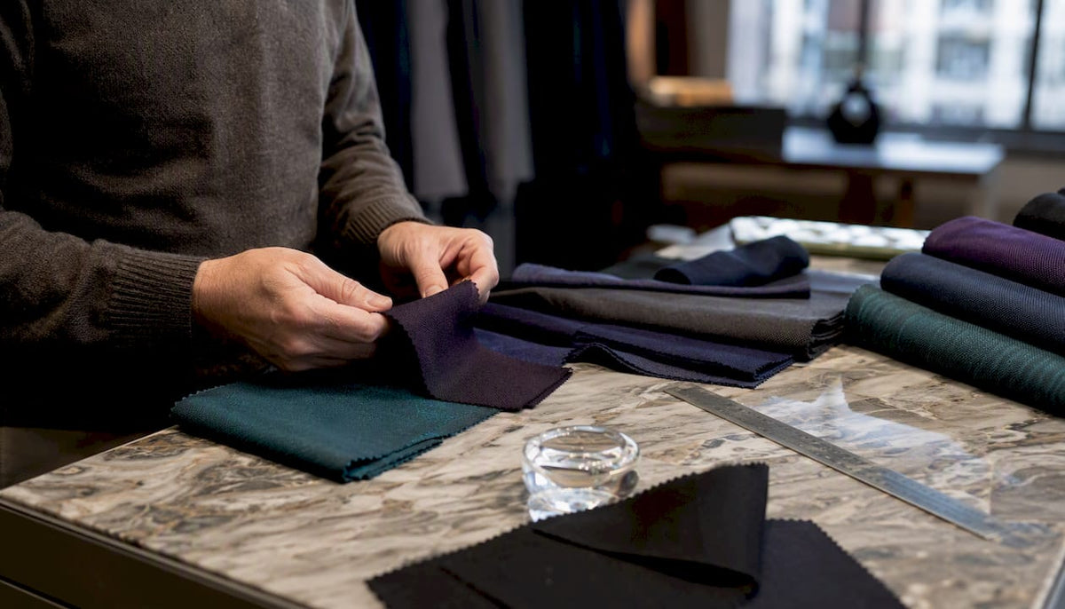 Hands inspecting sportswear fabric swatches