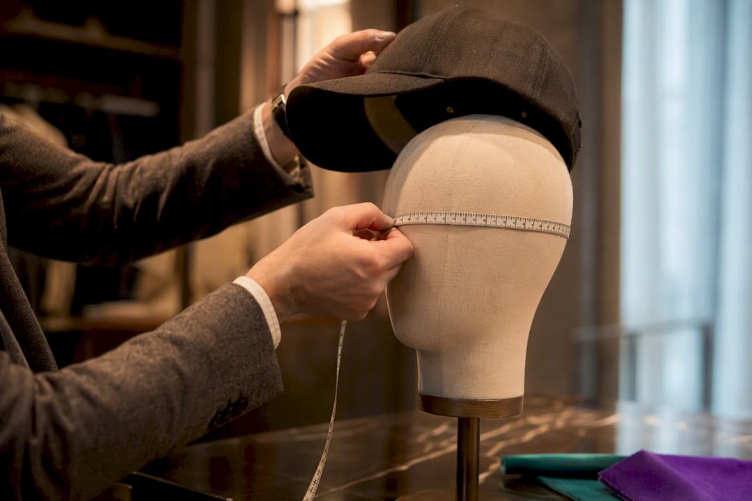 Measuring tape beside an anonymous cap crown